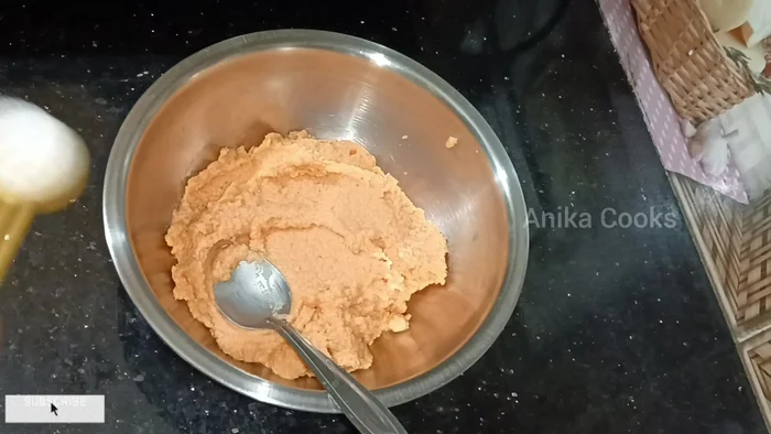 Transfer the ground moong dal to a bowl. Add salt, red chili powder, and chopped onion (or cabbage).
