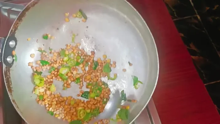 Add curry leaves and chopped green chilies to the roasted dal. Add asafoetida.