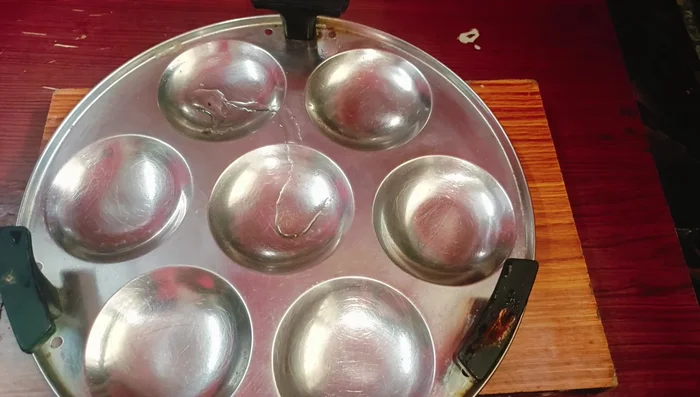 Grease idli molds with oil.