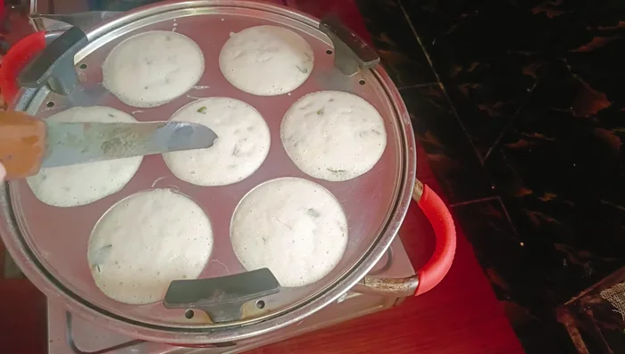 Once cooked, let the idlis cool slightly before removing them from the molds.