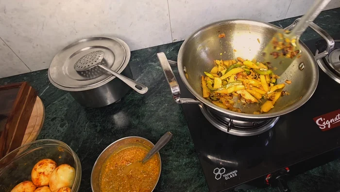 Stir the parwal (pointed gourd) while frying to make parwal bhujia.