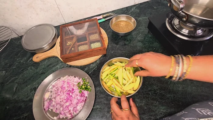 Cut potatoes and pointed gourd. Add green chilies and finely chopped onion to potatoes.