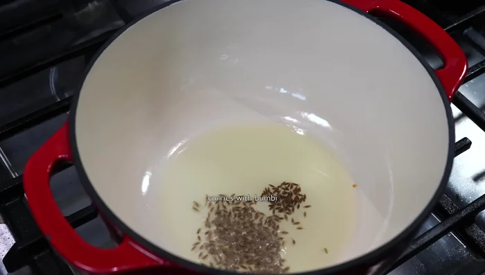 Heat oil in a pan. Add cumin seeds and black mustard seeds; fry until they splutter.