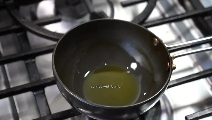 Heat ghee in a separate pan. Add chopped garlic and red chilies; fry until golden brown.