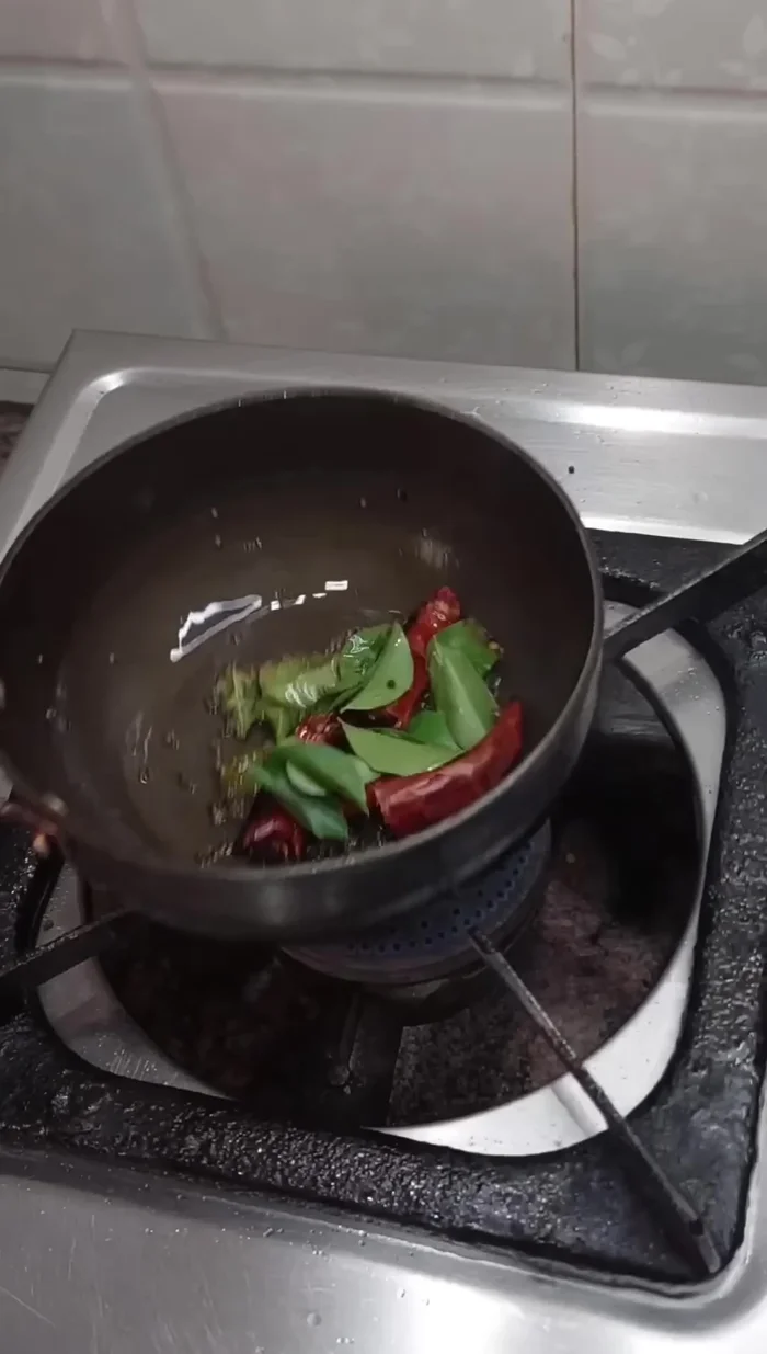 Prepare tadka for coconut chutney: Heat oil, add mustard seeds, red chilies, and Kariya Pak.