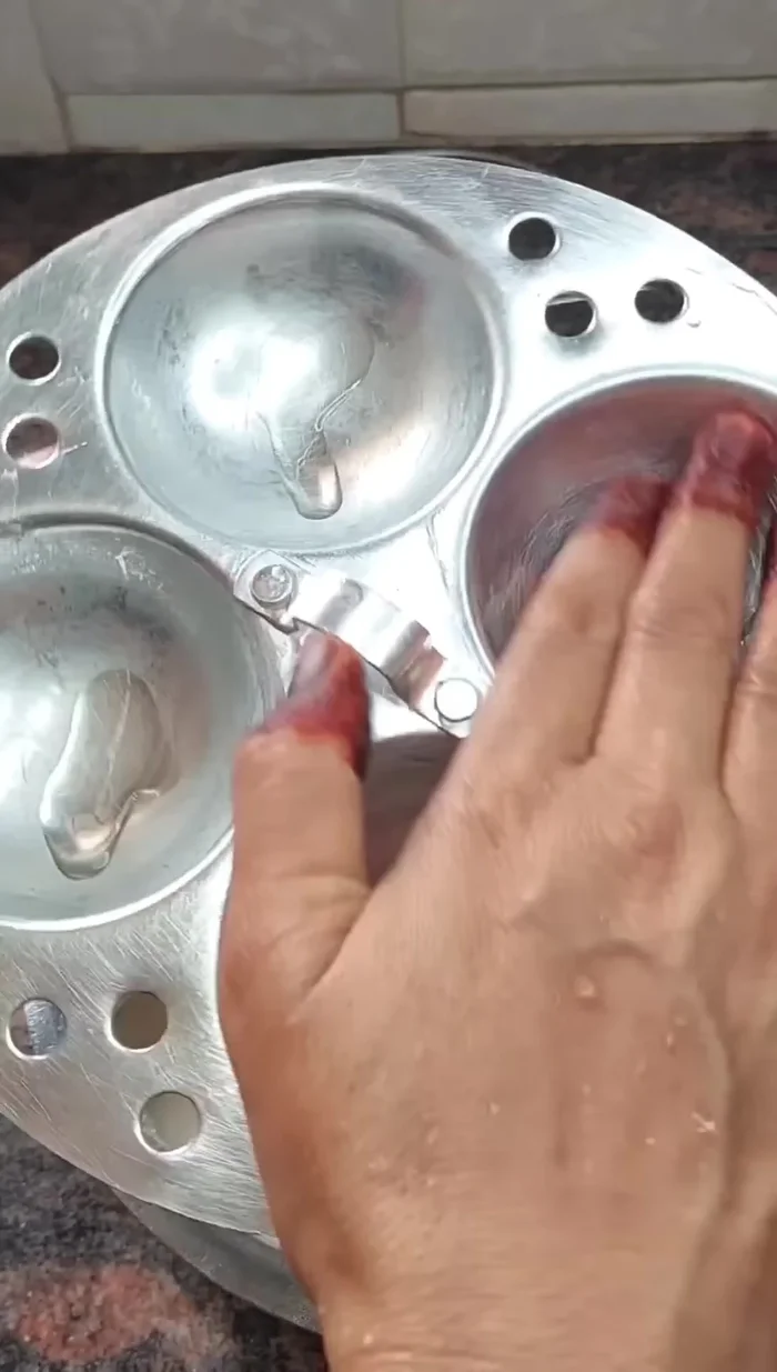 Grease the idli molds with oil.