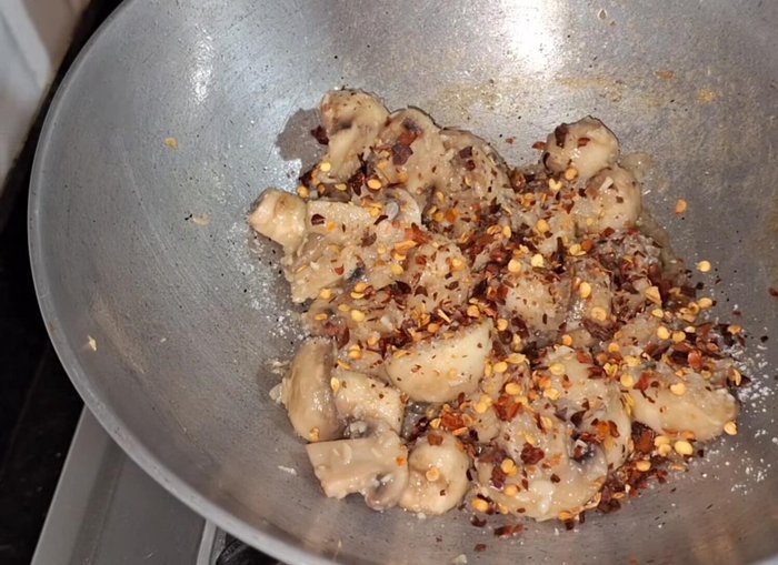 Season with salt, chili flakes, oregano, and pepper powder. Mix well.