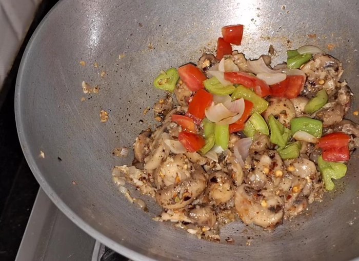 Add the previously sautéed onions, tomatoes, and capsicum. Mix everything together.