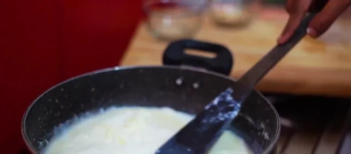 Add the grated paneer to the milk mixture and simmer until the paneer is cooked and the mixture has thickened slightly.