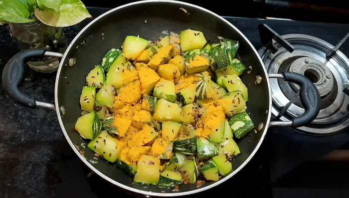 Add turmeric powder, red chili powder, and coriander powder. Mix well.