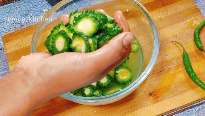 Squeeze out excess water from the bitter gourd.