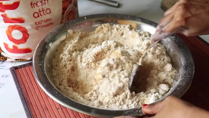 Gradually add the remaining 1/2 cup ghee, mixing until the dough forms a consistency that holds its shape when pressed.
