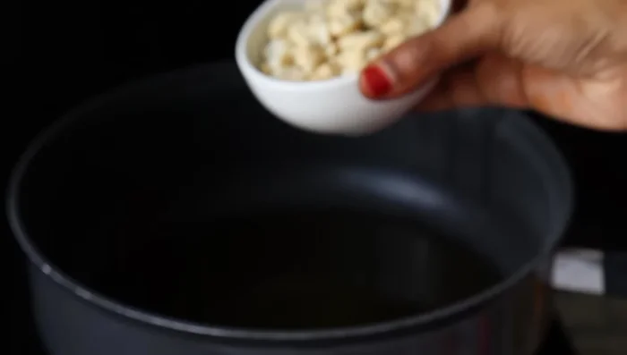Heat a pan and add 1/2 cup of ghee. Once hot, add 1/2 cup of finely chopped cashew nuts and fry until golden brown.