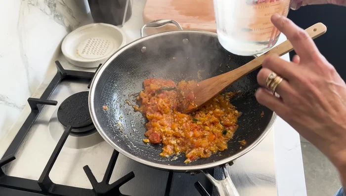 Turn off heat under the tomatoes. Add 100ml of water to cool slightly.