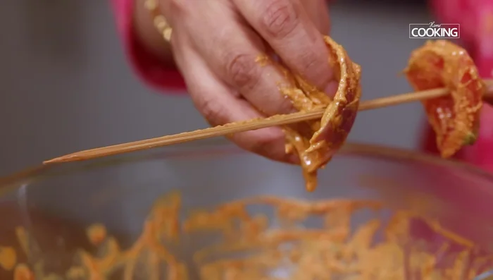 Assemble skewers: Thread tomato, onion, paneer, and capsicum onto skewers.