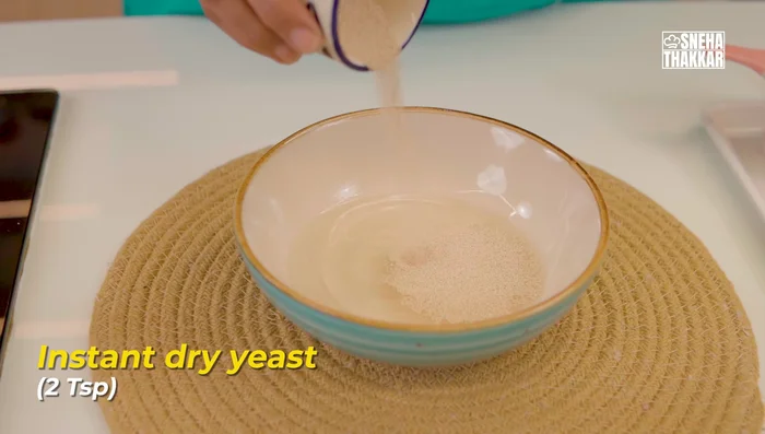Activate yeast: In a bowl, mix lukewarm water, instant dry yeast, and a little sugar. Whisk and let it stand for 5-7 minutes.