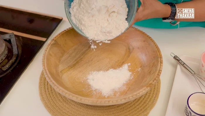 Prepare dough: In a vessel, sieve flour and make a well in the center. Add salt, garlic powder, and oil. Gradually add the yeast mixture, kneading until a soft dough forms.