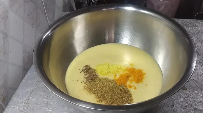 Mix ground moong dal with celery, asafoetida, coriander powder, turmeric powder, chili powder, salt, green coriander, and 1 spoonful of gram flour.