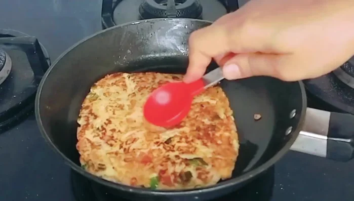 Once cooked, gently press a small indentation in the center of the bread omelette.