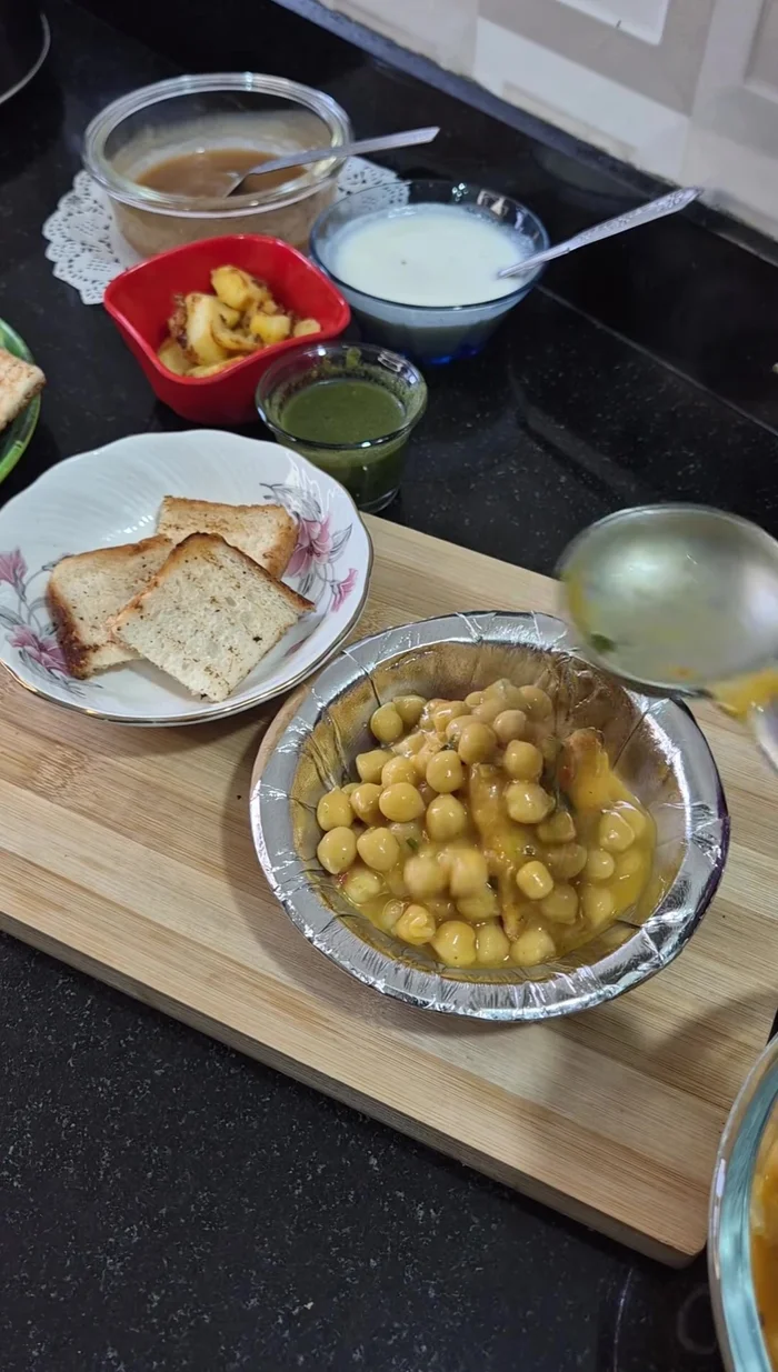 Layer bread pieces in a bowl. Top with chole, adding more water if needed. Add potatoes, whipped curd, green chutney, tamarind chutney, sweet and sour chutney, onion, potato bhujia, chaat masala, black salt, dry mango powder, and red chilli powder.