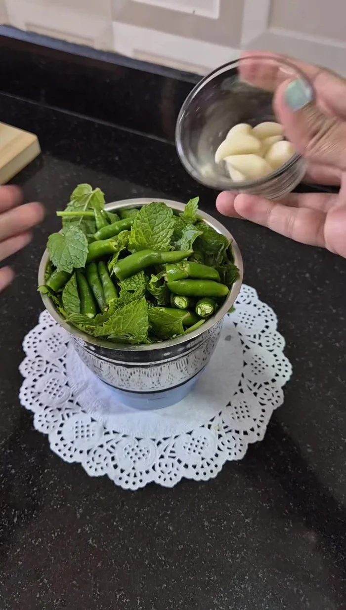 Prepare green chutney by blending coriander, mint, green chillies, garlic, chaat masala, black salt, cumin powder, salt, lemon juice, bread, and water.