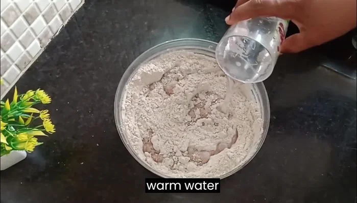 Add 1 cup of lukewarm water (or warm milk) and mix well to form a dough.