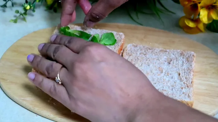 Add baby spinach, cucumber, onion, and tomato slices.