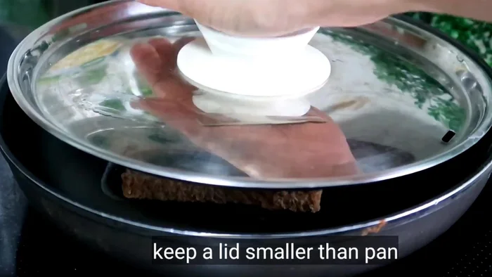 Butter a pan and cook the sandwich over low heat, covering it with a slightly smaller lid and a heavy utensil on top. Flip and cook the other side, buttering again when you flip.