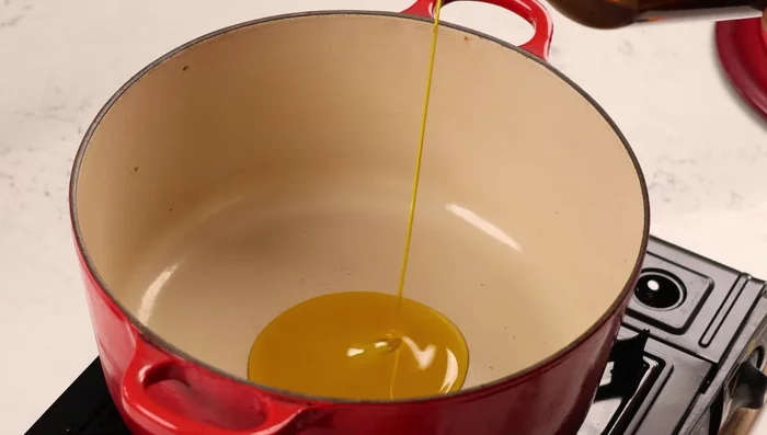 Heat mustard oil in a Dutch oven. Torch and add bay leaves (carefully!).