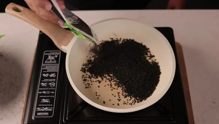 Toast black sesame seeds in a dry pan until fragrant and popping.