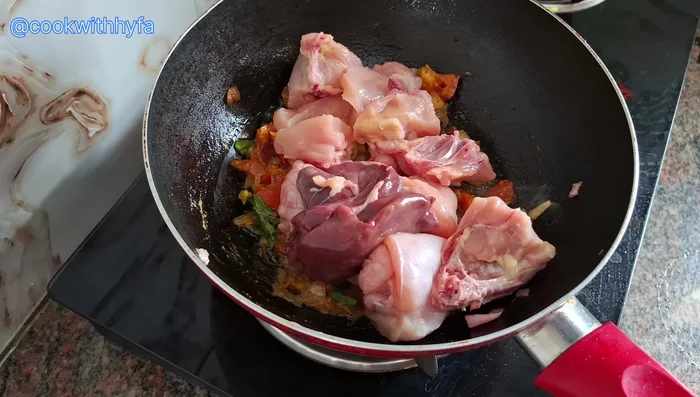 Add the cleaned and cut chicken pieces. Mix well with the spices and sauté for 1-2 minutes.
