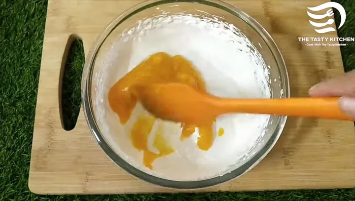 Gently fold in the chilled mango puree in 2-3 additions, using a cut and fold method to avoid deflating the cream.