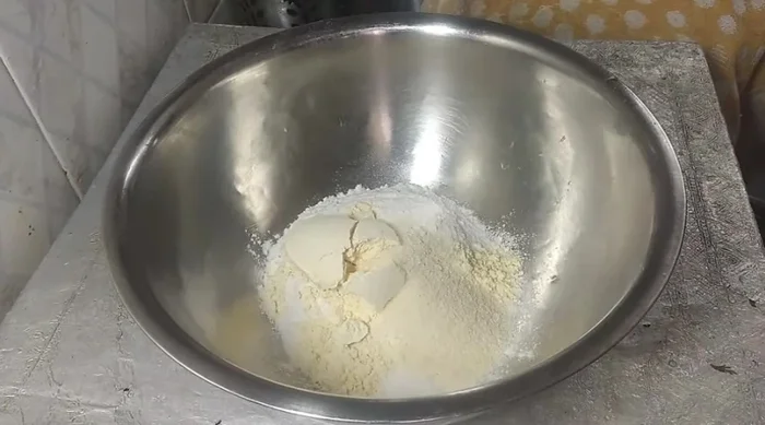 Prepare the batter: Mix rice flour, gram flour, semolina, salt, turmeric powder, asafoetida, coriander powder, chilli powder, chopped green coriander, fennel, and celery. Add water gradually to form a thin batter.