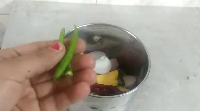 Prepare the chutney: Blend raw mango (with peel), onion, dried chillies, green chillies, mint leaves, green coriander, roasted cumin powder, and black salt with water.