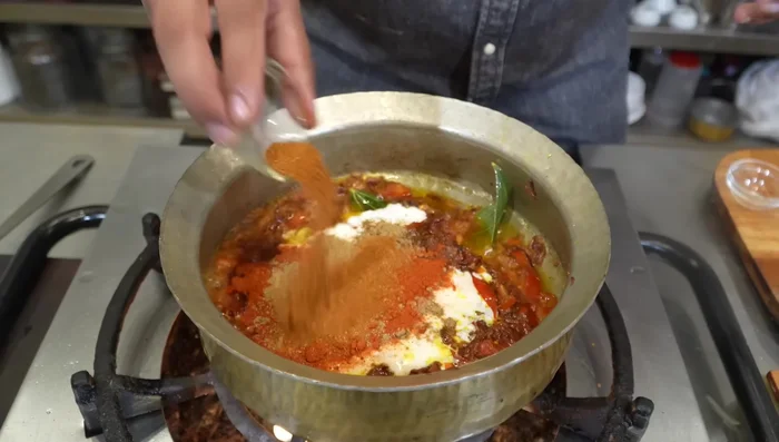 Stir in curd, coriander powder, chili powder, cumin powder, garam masala, green chilies, mint, and coriander. Cook for 1-2 minutes.