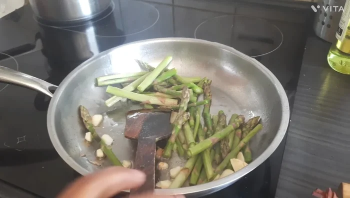 Add the cut asparagus to the pan. Stir-fry for a couple of minutes until slightly tender.