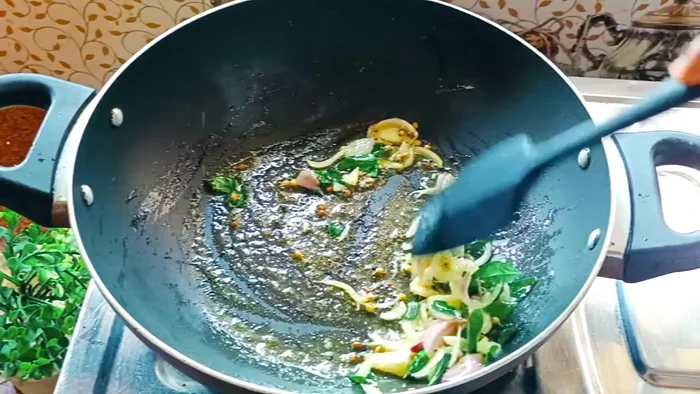 Add finely chopped onion and green chilies (optional) to the sambar masala and sauté until softened.