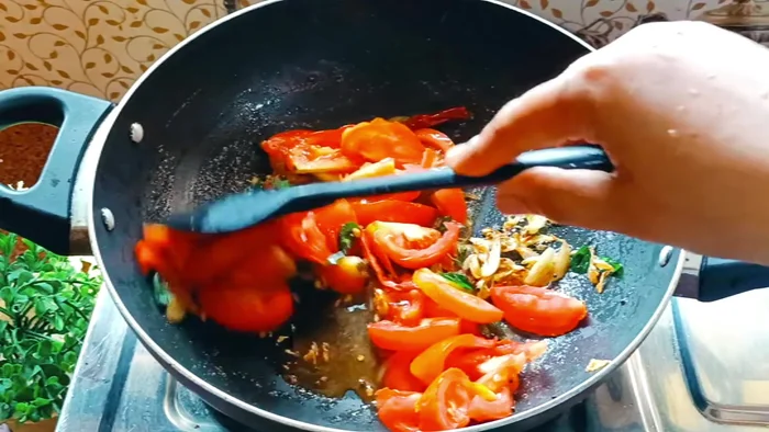 Add chopped tomatoes to the sambar masala and cook until soft. Add salt and turmeric powder.