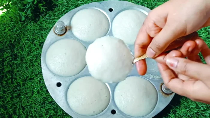 Let the idlis cool slightly before demolding. If needed, soak the mould briefly in hot water to facilitate easy removal.