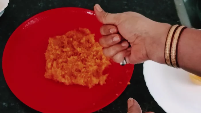 Apply ghee to your hands and shape the mixture into small laddus.