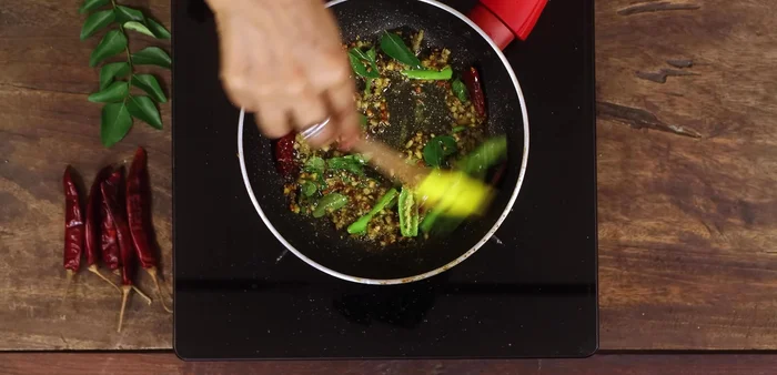Sauté everything well, then pour the tempering over the curd rice mixture.