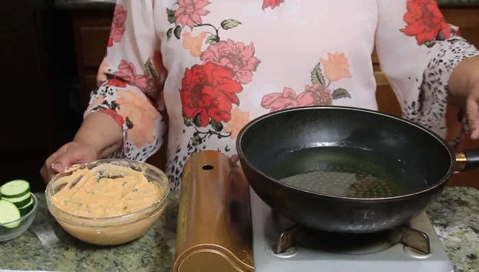 Heat oil in a frying pan over medium-high heat. Check if the oil is hot enough by adding a drop of batter – it should sizzle immediately.