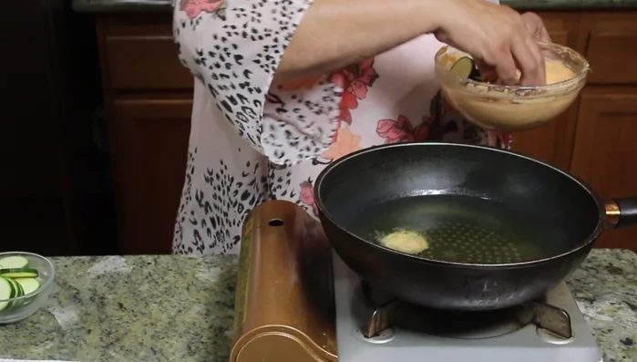 Gently drop spoonfuls of batter into the hot oil, ensuring not to overcrowd the pan.