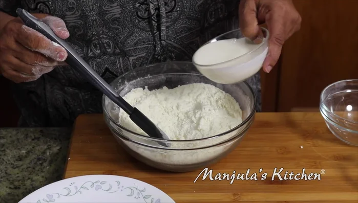 Gradually add heavy cream, reserving some if needed. The dough should be soft and slightly sticky.
