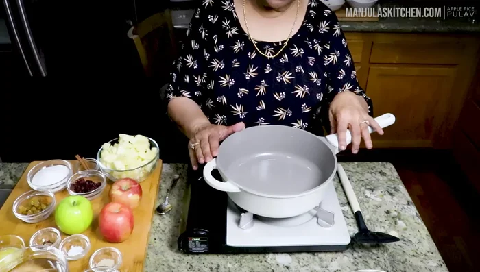 Make the apple sauce. In a heavy bottom pan, combine peeled and chopped apples, sugar, raisins, cranberries, salt, cloves, cinnamon sticks, and ghee.