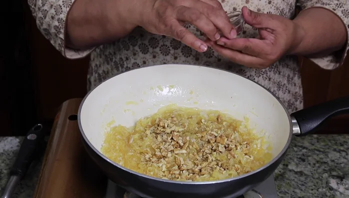 Add crushed walnuts and cardamom powder; mix well.
