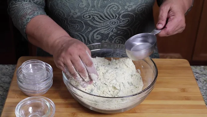 Gradually add lukewarm water, mixing until a soft dough forms. Reserve about 2 tablespoons of water if needed.