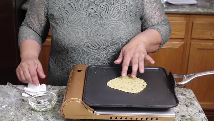 Cook the paratha on medium heat for about 20 seconds per side, until lightly browned and slightly puffed.