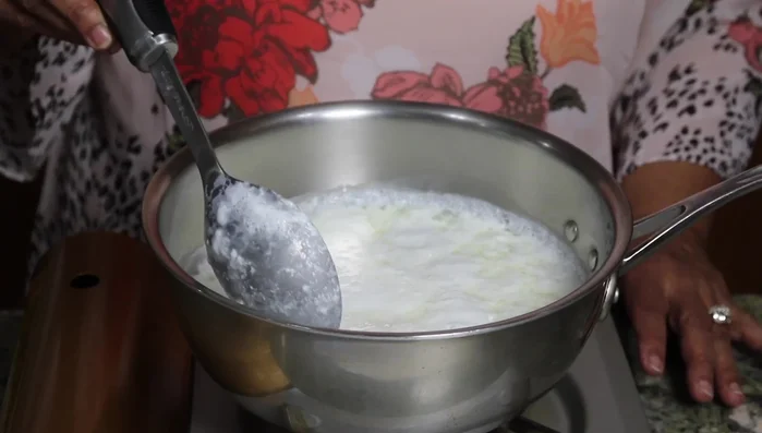 Add lemon juice to the boiling milk, stir, and let the milk fat separate. Drain the whey using a strainer lined with muslin cloth.