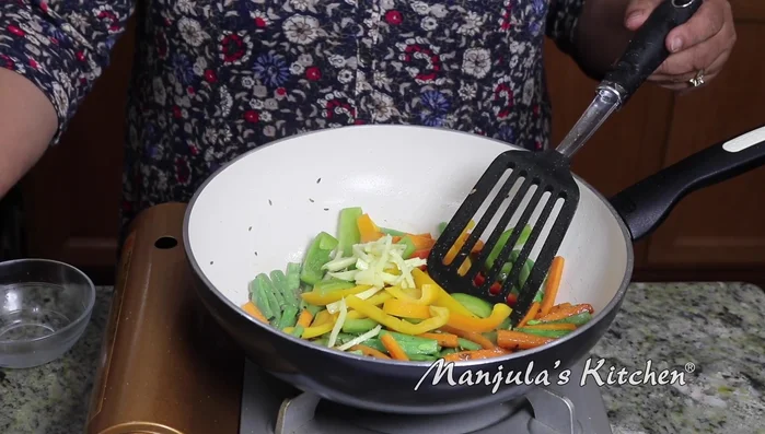 Add bell peppers, ginger, green chilies, and turmeric. Stir and lower heat to low-medium.
